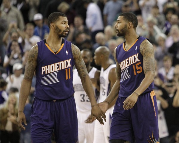 Phoenix Suns' Markieff Morris, left, shakes hands with his twin brother Marcus, as they walk off the court after the Suns 107-104 loss to the Sacramento King in a NBA basketball game in Sacramento, Calif., Tuesday, Nov. 19, 2013.(AP Photo/Rich Pedroncelli) 