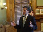 Gov. Sam Brownback speaks with reporters after meeting Monday with school officials and legislative leaders about ways to avoid future litigation over school finance.