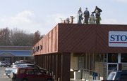 Peter Dahl, of Lawrence, sets up a Nativity scene Tuesday at the Hillcrest Shopping Center at Ninth and Iowa streets. Owner Dick Raney's grandmother Mildred, a choir director, originally wanted the Nativity scene bought and displayed atop the building more than 50 years ago.