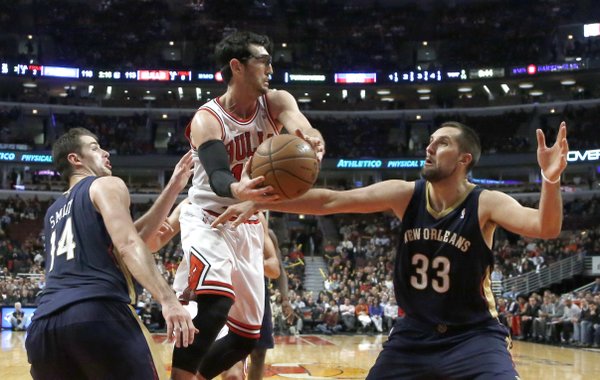 The New Orleans Pelicans's defense of Jason Smith, left, and Ryan Anderson (33) force Chicago Bulls shooting guard Kirk Hinrich (12) to pass the ball under the basket during the second overtime period of an NBA basketball game Monday, Dec. 2, 2013, in Chicago. The Pelicans won 131-128 in triple overtime. (AP Photo/Charles Rex Arbogast)