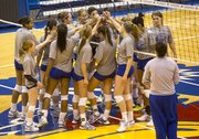 Kansas volleyball players gather around the net during their open practice Thursday at Allen Fieldhouse. The Jayhawks open the NCAA tournament Friday against Wichita State.