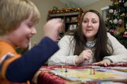 Jennifer Thornton plays a board game with her son Hayden after dinner Dec. 16, 2013. Jennifer is working on her masters in social work from KU and works at the Gillis Center in Kansas City.