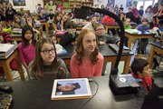 Kaila Bradfield, 11, left, and Hannah Vaughn, 12, watch a big screen with a live feed from Antarctica on Tuesday morning as their class talked with Carl Leuschen about his research there.