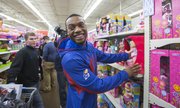 Kansas junior guard Naadir Tharpe flashes a smile at a fan who asked for a photo while shopping for charity Thursday, Dec. 19, 2013, at Wal-Mart on Iowa Street.