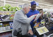 Roger Morningstar and Andrew Wiggins check a shopping list while shopping for charity Thursday, Dec. 19, 2013, at Wal-Mart on Iowa Street.