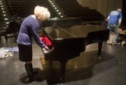 Margaret Morris, executive director of programs and partnerships at the Lawrence Arts Center, plays a few notes on the Arts Center's new Steinway piano just after it was unwrapped Thursday.