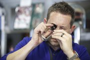 Jeff Neal, operating partner at Sunflower Pawn and Jewelry, 2429 Iowa St., uses a loupe to examine a Rolex watch being sold by a customer on Friday.