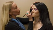 Liz Black applies eye shadow to Beth Grimm, 27 of Bonner Springs. Pantone's 2014 color of the year is Radiant Orchid.