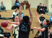 Free State’s Hannah Walter tries to pass the ball around the Leavenworth defense in the first half of a 47-33 Firebirds girls loss, Tuesday, Jan. 14, 2014, at FSHS.