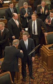 Gov. Sam Brownback greets Rep. Paul Davis D-Lawrence, as Brownback enters the House of Representatives to deliver his State of the State address at the Statehouse in Topeka, Wednesday, Jan. 15, 2014.