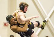 Free State freshman Tyreik Gooch, left, throws Topeka High's Daniel Stous to the mat during their 152# wresting match, Thursday evening at FSHS.