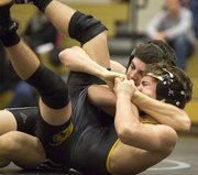 Free State sophomore Sid Miller, back, hooks the leg of Topeka High's Johnny Thomas as he works for a pin during their 120# wresting match, Thursday evening at FSHS.