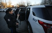 Patrol officer Ashley Durazo runs a safety check on a weapon as she prepares to begin her evening shift.