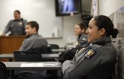 Patrol officer Ashley Durazo, 24, laughs as her fellow officers joke with each other toward the end of a recent shift briefing at the Douglas County Judicial and Law Enforcement Center. Durazo has been with the Lawrence Police Department for a little over two years and is among the youngest of the officers.