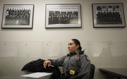 Patrol officer Ashley Durazo, 24, sits below portraits of police officers from years past during a recent shift briefing at the Douglas County Judicial and Law Enforcement Center. Durazo has been with the Lawrence Police Department for a little more than two years and is among the youngest of the department's officers.