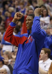 Injured Kansas center Joel Embiid celebrates a dunk by forward Tarik Black during the second half on Saturday, Feb. 15, 2014 at Allen Fieldhouse.