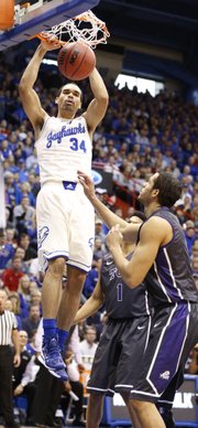 Kansas forward Perry Ellis delivers a dunk before TCU forward Amric Fields during the first half on Saturday, Feb. 15, 2014 at Allen Fieldhouse.