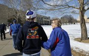 Kansas basketball snowbird Rosalie Gerstner, Ness City, walks arm-in-arm with her grandson Brian Gerstner, Baldwin City, as the two make their way to Allen Fieldhouse prior to tipoff of the Jayhawks' game against the Horned Frogs of TCU on Saturday, Feb. 15, 2014. For years, Gerstner would make the 300-mile trip from Ness City for the home games, but now retired, has decided to rent an apartment in Lawrence during basketball season.