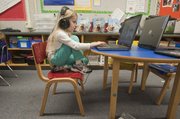 Samantha Dillon uses a laptop computer during reading time in Lauren Mitchell's full-day kindergarten class at Kennedy Elementary School.