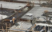 A worker removes snow, one shovel at a time, from the surface of the planned multi-story hotel building, currently under construction at the southeast corner of Ninth and New Hampshire. Developers are asking city commissioners to restart the approval process for a seven-story apartment building at the northeast corner of the same intersection.