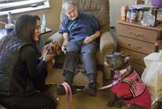 Mike Yoder/Journal-World Photo. Raven Rajani, founder and director of Loving Paws Animal Assisted Therapy, left, visits Marion Counts, center, a resident at Brandon Woods at Alvamar, with her dogs, Brahma, left and therapy dog Shakti, right. The therapy animal teams provide services throughout the community, including visits to community centers, nursing care facilities and schools.