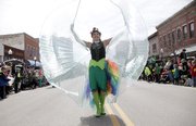 A super-hero participant walking along with the VFW float, spreads her wings on Massachusetts St. Monday, March 17, 2014 during the St. Patrick's Day Parade.