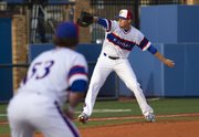 Kansas junior pitcher Wes Benjamin delivers a pitch as junior Blair Beck holds a runner near first base during Kansas' game against Oklahoma, Friday evening at Hoglund Ballpark.
