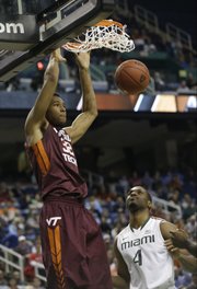 Virginia Tech’s Trevor Thompson (32) dunks as Miami’s Raphael Akpejiori watches in this photo from March 12, in Greensboro, N.C. Thompson has been granted his release and has been contacted by Kansas University coaches, according to a published report.