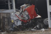 A tractor-trailer cab is wrapped around a tollbooth at the eastern terminal of the Kansas Turnpike on March 29. One person died and another is in critical condition after the truck hit the tollbooth about 3 a.m. The truck was carrying garden hoses.