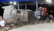 A tractor-trailer cab is wrapped around a tollbooth at the eastern terminal of the Kansas Turnpike on March 29. One person died and another is in critical condition after the truck hit the tollbooth about 3 a.m.