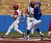 Oklahoma's Hunter Haley, left, scores on a wild pitch as Kansas senior pitcher Frank Duncan (19) is unable to handle the ball during the final game of Kansas' three game series against Oklahoma, Sunday afternoon at Hoglund Ballpark. The Jayhawks defeated the Sooners, 4-3, and with the victory they avoided a series sweep by Oklahoma.