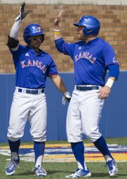 Kansas' Justin Protacio, left, and Tucker Tharp celebrate Tharp's run during the final game of Kansas' three game series against Oklahoma, Sunday afternoon at Hoglund Ballpark. The Jayhawks defeated the Sooners, 4-3, and with the victory they avoided a series sweep by Oklahoma.