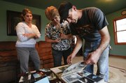 Ed Elmer sorts through a photo album Thursday at his home in Oskaloosa. The photos are of his years living in Washington State, where his family home near Oso was destroyed by the massive landslide on March 22 that killed dozens of people. With Elmer are his wife, Jennifer Elmer, and mother-in-law, Mari McKee, both of whom had also lived in the Washington home before moving to Kansas a few years ago.