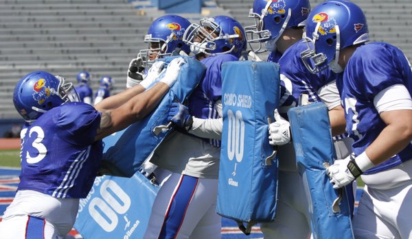 Kansas offensive lineman Damon Martin, left, works with other offensive lineman during drills at a KU football practice Saturday, April 5, 2014, at Memorial Stadium.