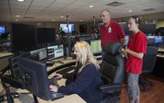 Lori Alexander, deputy director of Douglas County Emergency Communications describes the new system to Duane Filkis, the Kanwaka fire chief, and volunteer firefighter Makayla White. A remodeled center and radio system was unveiled to the public on Wednesday.