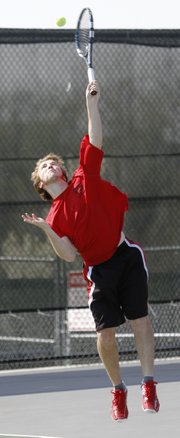 Lawrence High tennis player Thomas Irick serves during his No. 1 doubles tennis match against Free State in the City Showdown on Tuesday, April 15, 2014, at FSHS.