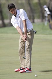 Lawrence High golfer Brent Cahwee putts Wednesday at Eagle Bend during the Free State High School Invite golf tournament.