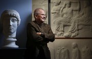 Kansas University classics professor Stanley Lombardo is pictured next to a cast of the Greek god Apollo and casts of friezes from the Parthenon April 24 in the Wilcox Classical Museum at KU’s Lippincott Hall. Lombardo, who is internationally known for translating ancient classics, is retiring after 37 years at KU.