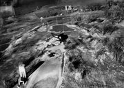 This aerial photograph shows the Lawrence Country Club at center and the surrounding land that would be shaped into the golf course. This view is from the south looking north over the clubhouse with a parking lot pictured on the south side at bottom of the photo. This south side entrance would be the Country Club Terrace street access today.