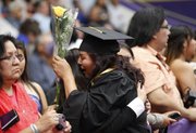 LaReina Jim, Paiute Tribe, Schurz, Nev., gets a yellow rose from her friend Shanice Valencia, after receiving her diploma on Friday at Coffin Sports Complex.
