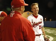 Lawrence High baseball coach Brad Stoll, left, congratulates Jacob Seratte after Seratte's hit in the ninth inning Thursday night at Hoglund Ballpark. The Lions defeated the Firebirds, 5-4.