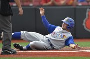 Kansas University’s Justin Protacio slides into home to score a run in the second inning of the Jayhawks’ 10-6 victory over No. 22 Kentucky in an NCAA Tournament game Friday in Louisville, Kentucky.