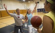 From left, Free State High assistant girls basketball coach Kevin Riley shows senior Hannah Shoemaker how to defend the paint at camp Wednesday, June 4, 2014, at Southwest Middle School.