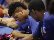 Kansas newcomer Kelly Oubre signs a jersey for a basketball camper along with the rest of the Jayhawks on Sunday, June 8, 2014, at Allen Fieldhouse.