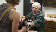 Veterinarian Herschel Lewis, 78, has been practicing in Lawrence the same way for decades: not taking appointments, no fancy equipment or technology. Here, he examines Kelly Farlow's dog, Skye, for a skin ailment at the clinic at 3101 W. Sixth St. on Friday.