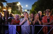 Concert goers smile with anticipation as Johnny Winter takes the stage during a performance Wednesday night outside of the Lawrence Arts Center as part of the Free State Festival. Prior to the concert, a documentary on the life and career of Winter, Johnny Winter: Down and Dirty, was shown at the Arts Center.