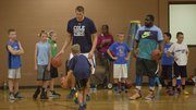Former Kansas basketball player and current NBA player Cole Aldrich, left, and former KU player Sherron Collins work with campers at Aldrich's basketball camp Monday, July 7, 2014, at Robinson Gym at KU.