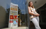 Caroline Mathias, owner of Foxtrot, 823 Massachusetts St., is pictured outside her store and next to a window display featuring dancing foxes from "Fantastic Mr. Fox" that she created.