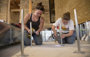 From left, architecture graduate students Renee Brune, 25, and Christina Harwood, 23, screw pedestals to flooring inside the new Marvin Hall addition.
