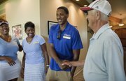 Miami Heat point guard and former Kansas University standout Mario Chalmers, center, greets former KU radio announcer Max Falkenstien during the Sixth Annual Mario V. Chalmers Foundation Golf Tournament & VIP Mixer at Alvamar Golf Club. At left are Mario's sister Roneka, and his mother Almarie.